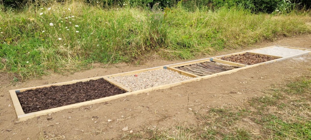 Barfußpfad mit Feldern aus Rinde, Kies und Sand