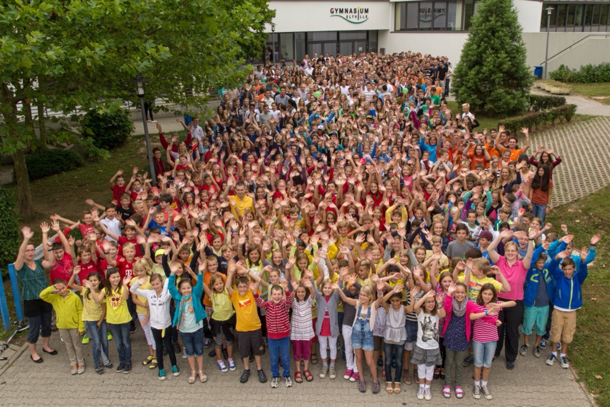 Hunderte Schülerinnen und Schüler winken vor dem Haupteingang des Gymnasiums Eltville